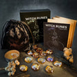 Witch Runes set with books, bag, and candles on a dark background