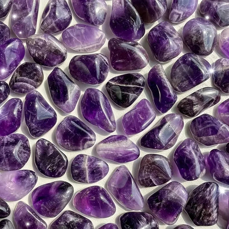 Close-up of purple tumbled stones on a white background