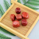 Red stones on a bamboo mat with green leaves in the background