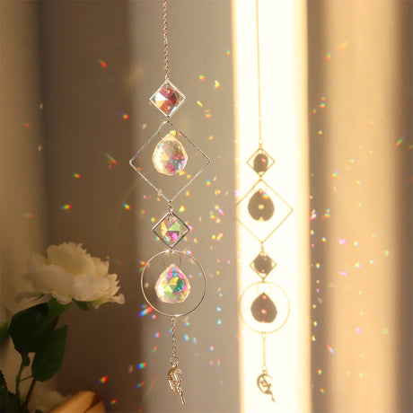 Decorative hanging crystal with rainbow, placed against a neutral background.