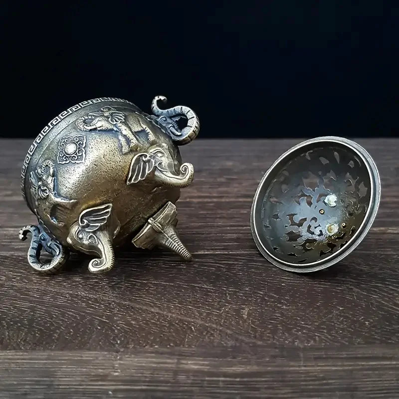 Decorative metal object with intricate designs on a wooden surface