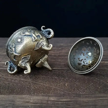 Decorative metal object with intricate designs on a wooden surface