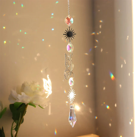 Hanging crystal ornament with rainbow, placed against a neutral background.