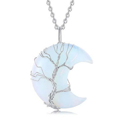 Crescent moon-shaped pendant with tree design on a white background