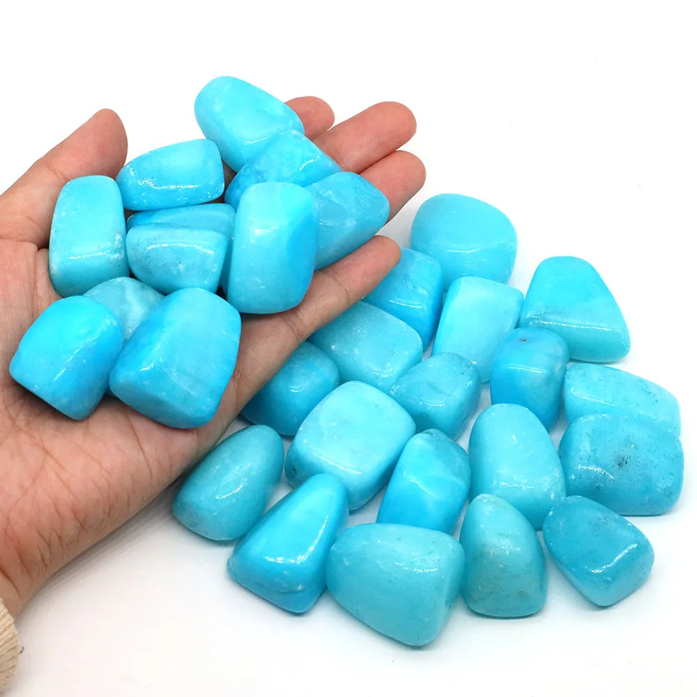 Turquoise stones held in a hand against a white background