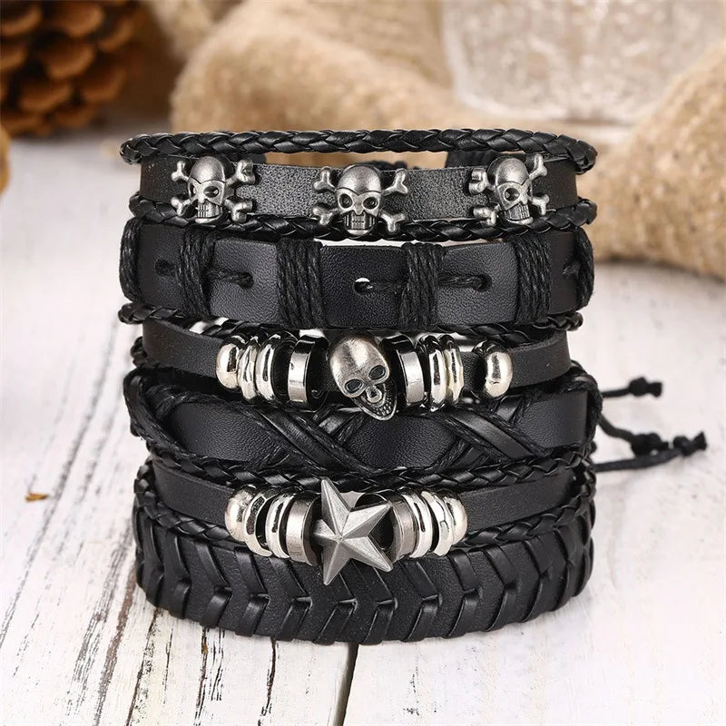 Stack of black leather bracelets with skull and star charms on a light wooden surface.