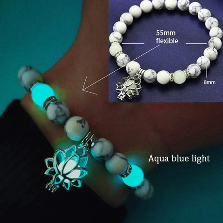 Glowing bracelet with white beads and lotus charm on a hand, with close-up details on a blue background.