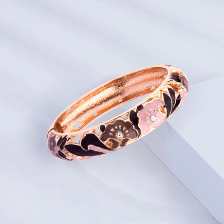 Rose gold bracelet with floral design on a light gray background