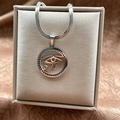 Copper eye pendant necklace on a beige jewelry box
