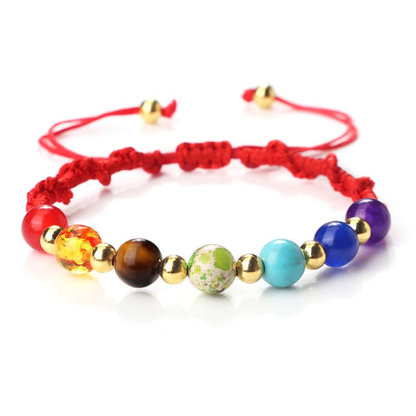 Colorful beaded bracelet with red string on a white background