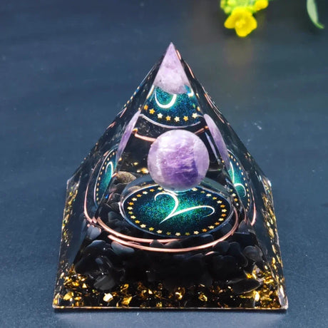 Decorative pyramid with purple crystal ball on a dark background