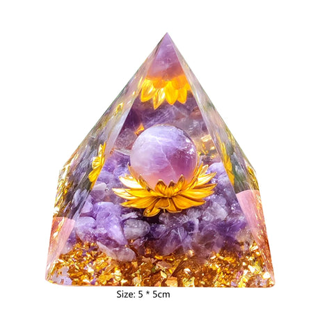 Pyramid-shaped crystal with purple sphere and yellow flowers on a white background