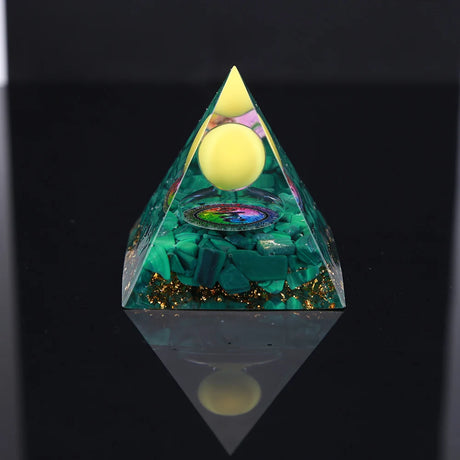 Pyramid-shaped object with glowing yellow spheres and green material on a black background