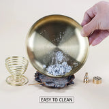 Brass incense dish with ash, surrounded by small components on a light background.