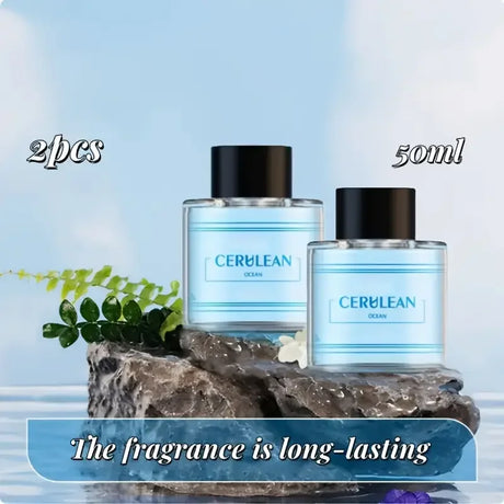 Two bottles of CERULEAN Ocean perfume on a rock with a light blue background