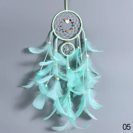 Turquoise dreamcatcher with feathers on a gray background