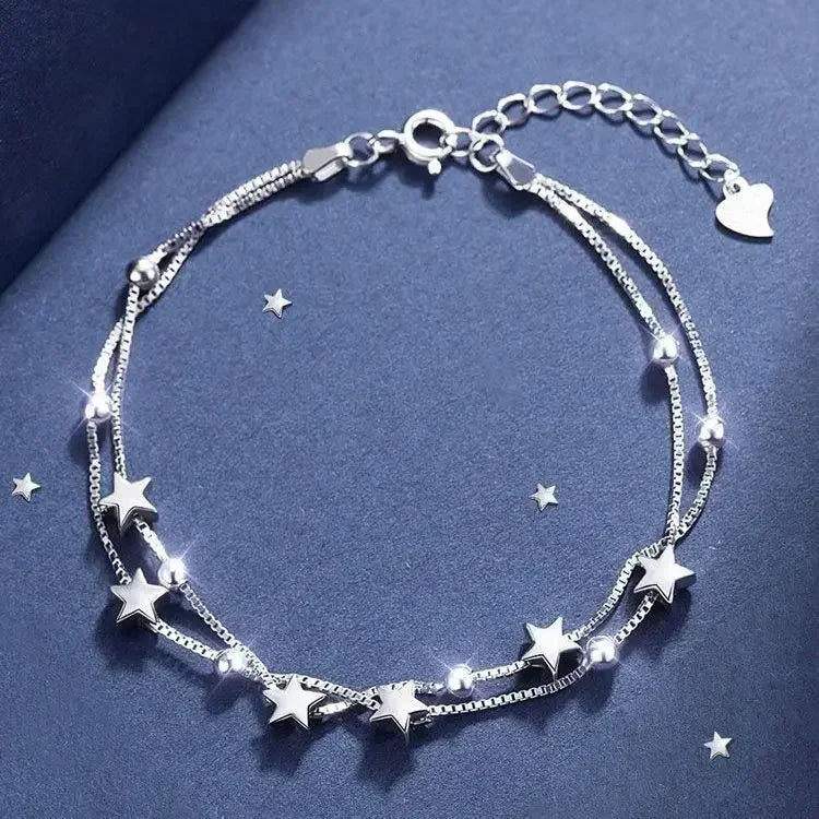 Silver bracelet with star charms on a blue background
