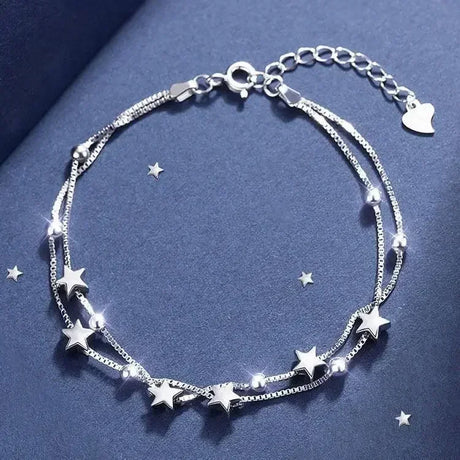 Silver bracelet with star charms on a blue background