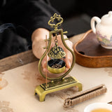 Decorative incense holder with smoke on a table with tea set in the background