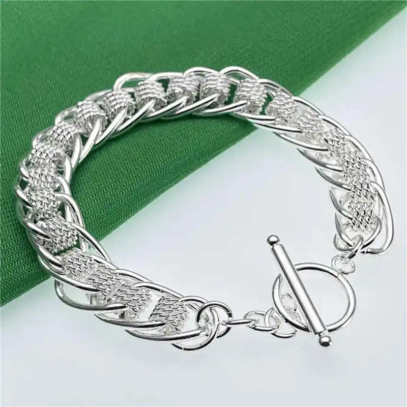 Silver bracelet on a green and white background