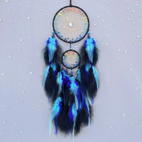Dreamcatcher with blue and black feathers on a starry background
