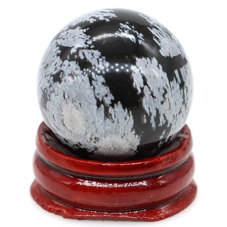 Black and white marbled sphere on a red stand against a white background