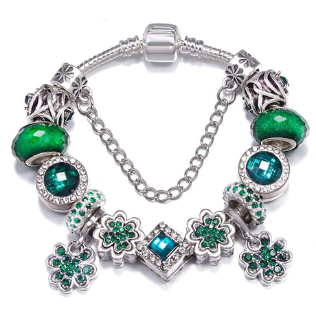 Bracelet with green and silver charms on a white background