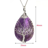 Purple tree-shaped pendant with silver wire wrapping on a white background