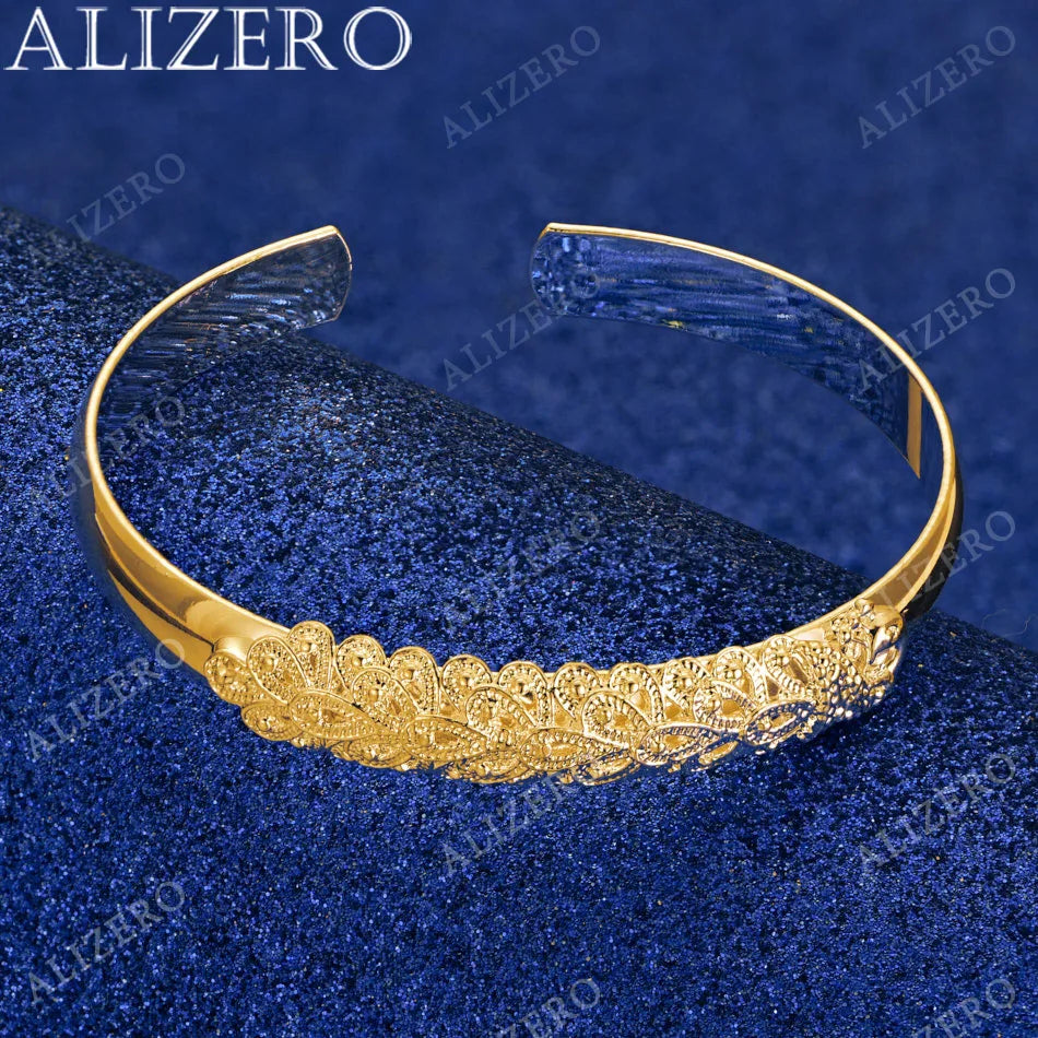 Gold bracelet with intricate design on a blue textured background, featuring the brand 'ALIZERO'.