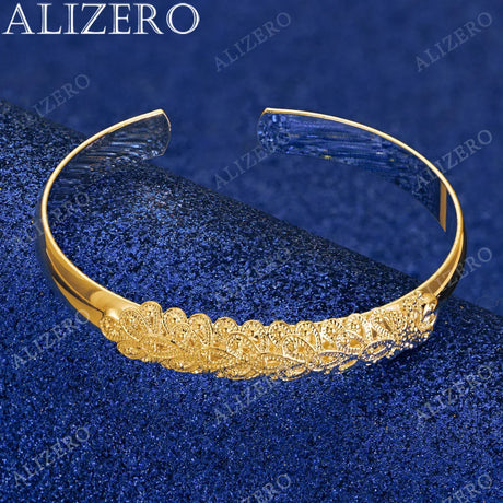 Gold bracelet with intricate design on a blue textured background, featuring the brand 'ALIZERO'.