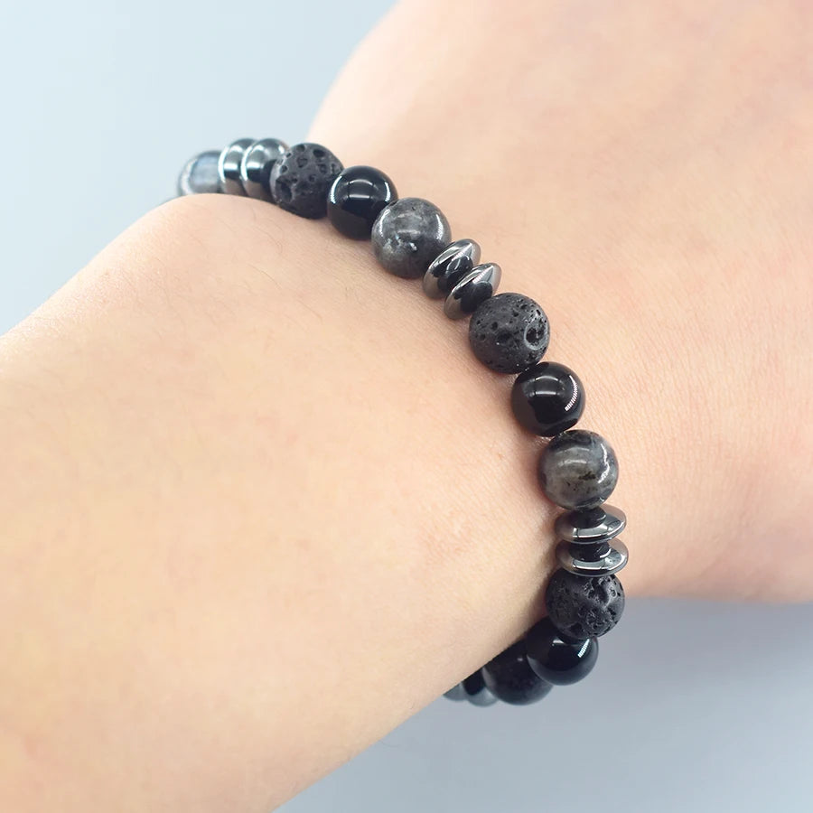 Black beaded bracelet on a wrist against a light background