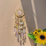 Decorative sun and moon hanging ornament with crystals and flowers on a neutral background
