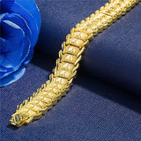 Gold bracelet on a blue fabric background with a blue flower