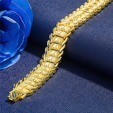 Gold bracelet on a blue fabric background with a blue flower