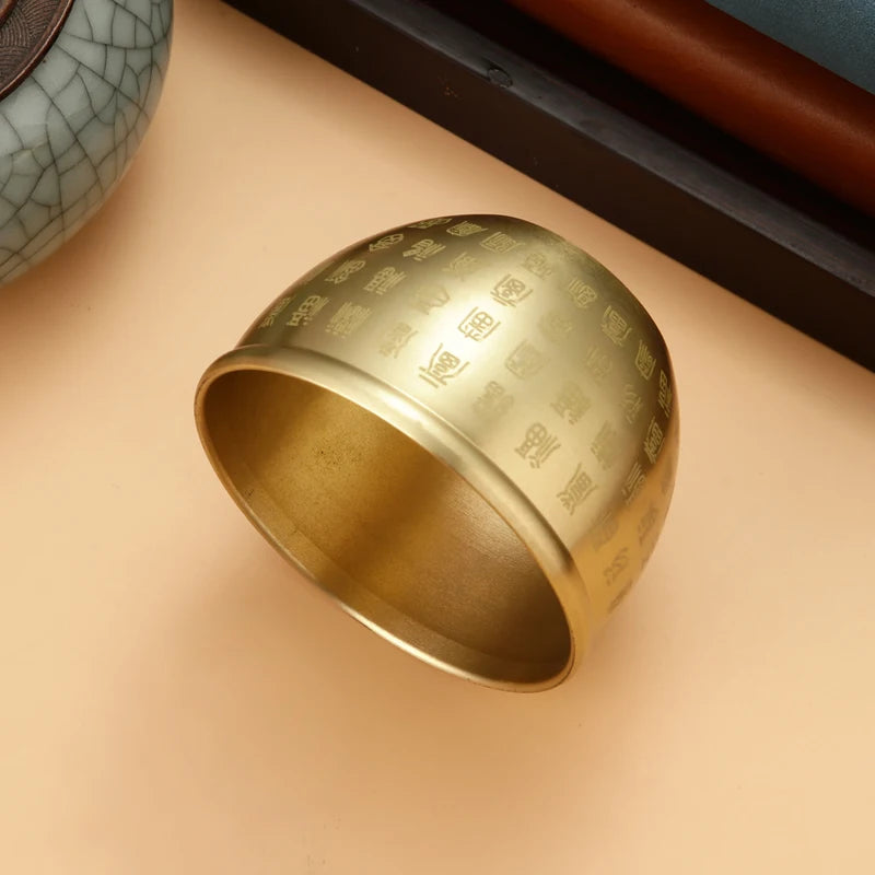 Gold ring with engraved patterns on a beige surface