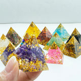 Colorful pyramid-shaped decorative items with embedded stones on a white surface.