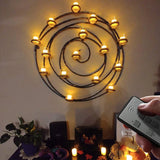 Decorative wall light fixture with candles and a remote control in a room setting.