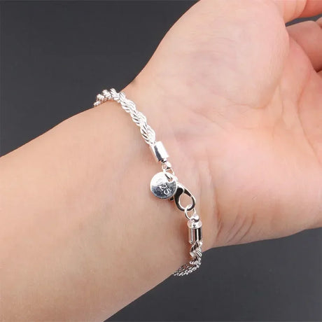 Silver bracelet on a wrist against a dark background