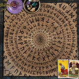 Wooden surface with engraved symbols, tarot cards, and crystals on a dark background
