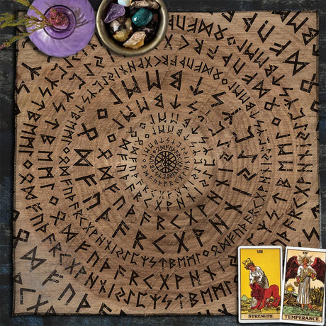 Wooden surface with engraved symbols, tarot cards, and crystals on a dark background