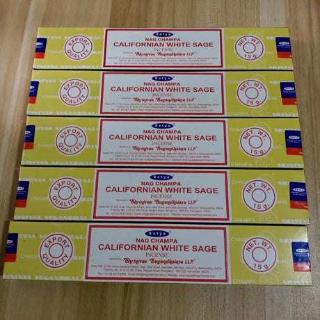Multiple boxes of Nag Champa Californian White Sage incense on a wooden surface