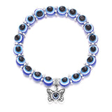 Bracelet with blue and black beads and a butterfly charm on a white background