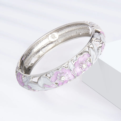 Silver bracelet with pink floral designs on a white background
