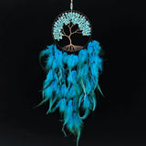 Turquoise dreamcatcher with feathers and tree of life design on a black background