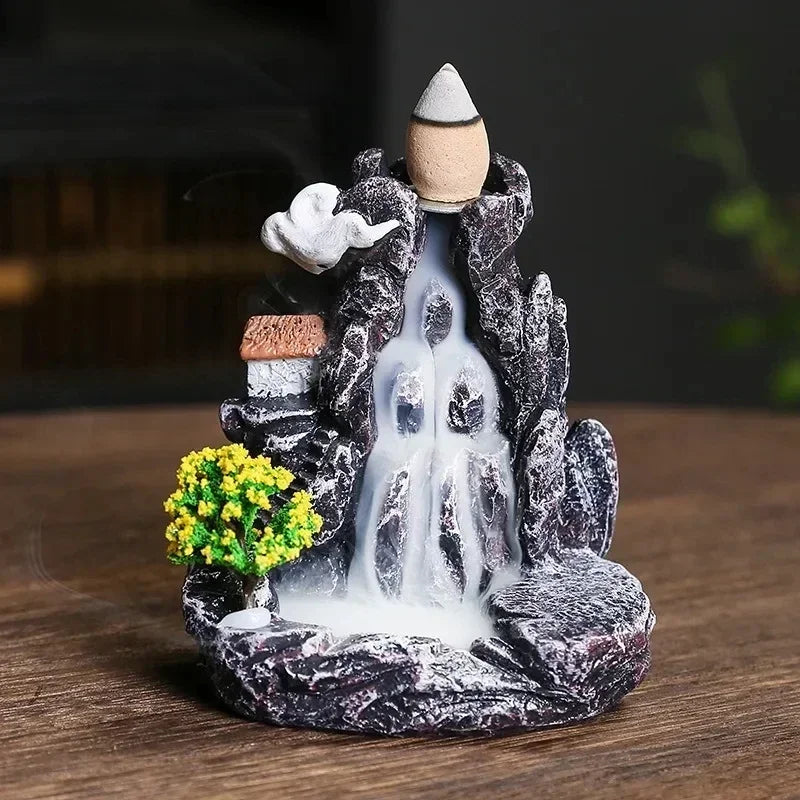Decorative mountain with waterfalls and plants on a wooden surface