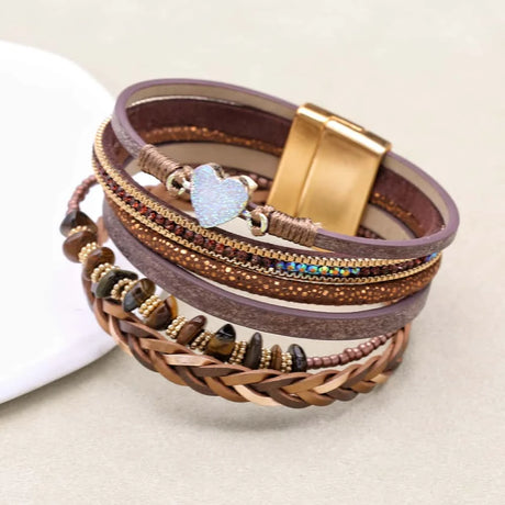 Multistrand bracelet with braided design and metal clasp on a light background