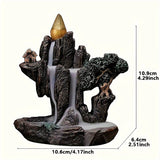 Decorative backflow incense burner with a mountain and house design, featuring a small golden cone on top.