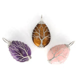 Three tree-shaped stone pendants in purple, brown, and pink on a white background