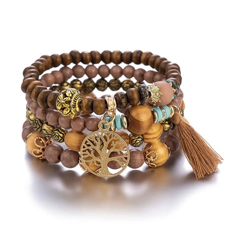 Stack of wooden beaded bracelets with gold charms and a tassel on a white background