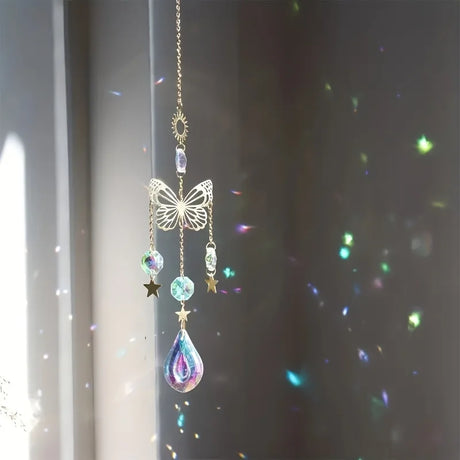 Decorative hanging ornament with butterfly and teardrop design against a dark background